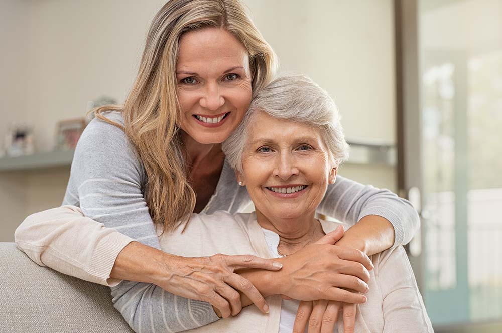 A woman in her 40s and a senior woman smiling after designating a power of attorney